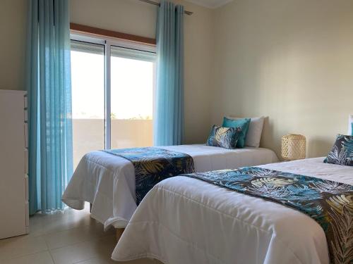 una camera d'albergo con due letti e una finestra di Apartamento T2 com piscina em Conceição e Cabanas de Tavira a Tavira