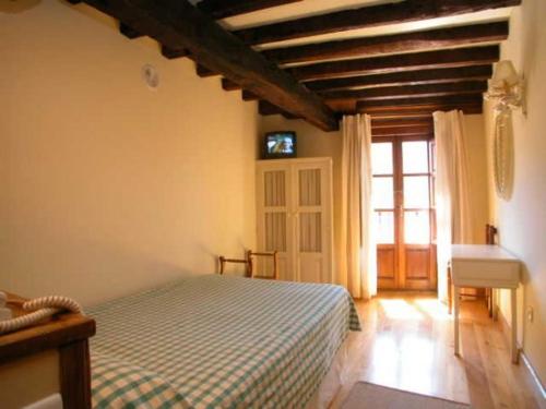 a bedroom with a bed and a desk and a window at Hostería La Antigua in Potes