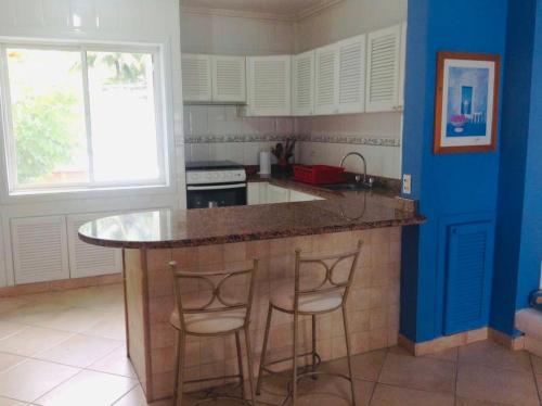 a kitchen with a island with two bar stools at Precioso Dpto a 20 metros de la playa Con Aire Acondicionado en Club Casablanca in Same