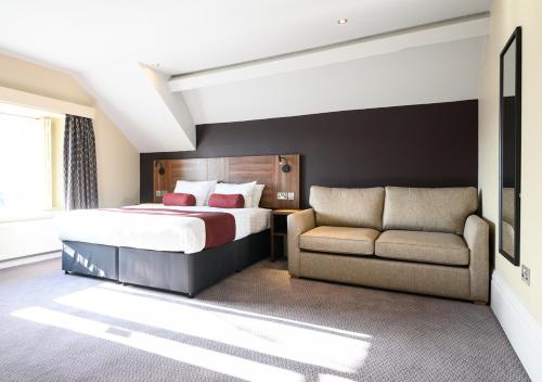 Habitación de hotel con cama y sofá en Miller & Carter Aughton by Innkeeper's Collection, en Ormskirk