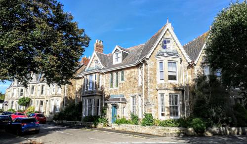 a large brick house with cars parked in front of it at Treventon Guest House in Penzance