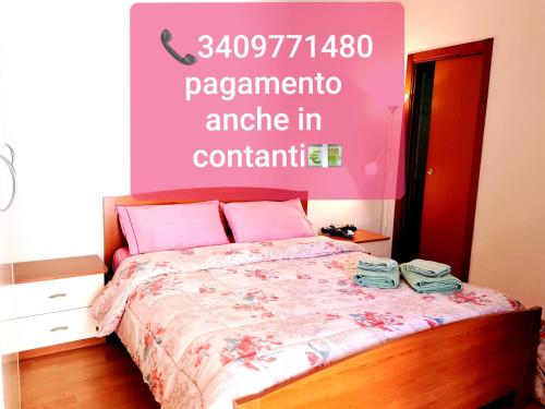 a bedroom with a bed with a pink wall at La Casetta Mini Appartamento Centro Storico in Reggio di Calabria