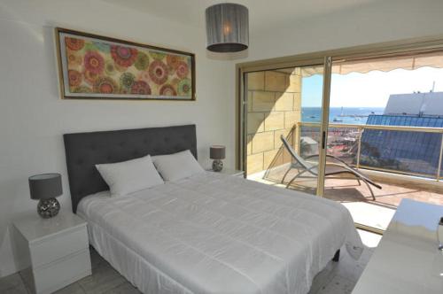 une chambre avec un grand lit et un balcon dans l'établissement Cannes - Croisette - Palais des Festivals, à Cannes