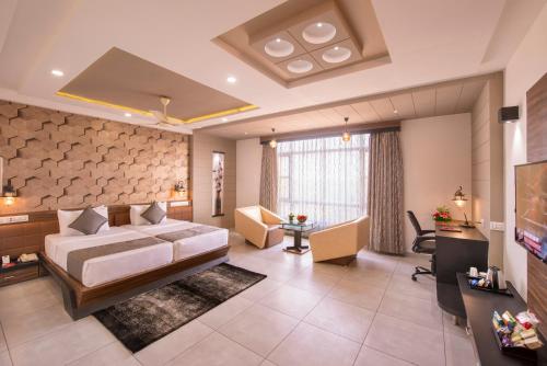 a large bedroom with a bed and a living room at Lords Eco Inn Morbi in Morbi