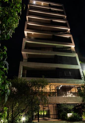 a tall building at night with its lights on at 8010 Urban Living- Luxury Home Experience in Bogotá