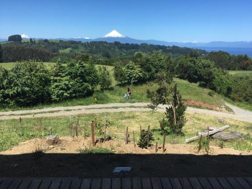 a person riding a bike on a hill with a mountain in the background at Casa Exclusiva en Puerto Octay - Espectacular Vista in Puerto Octay