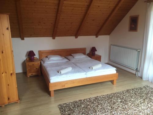 a bedroom with a bed with two night stands and two lamps at Anonim Vendégház in Villány