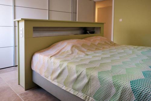 a small bed in a small room with a bedskirtspectspectspects at Hasbania Vakantiewoning in Gingelom