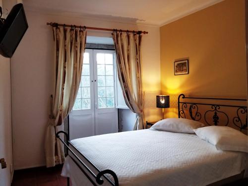 a bedroom with a bed and a window at Casa do Arco in Sintra