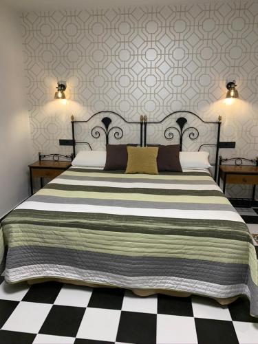 a bedroom with a large bed with black and white stripes at Hostal El Lechuguero in Cascante