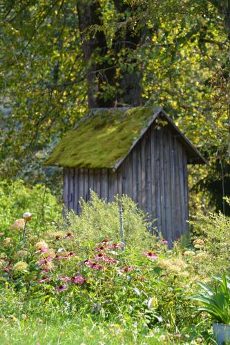 a small shed with a grass roof in a garden at Höblinghof in Schwarzau im Gebirge