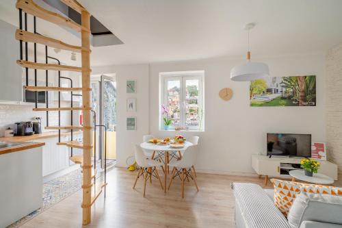 a kitchen and a living room with a spiral staircase at BestVillas Casa do Rio in Vila Nova de Gaia