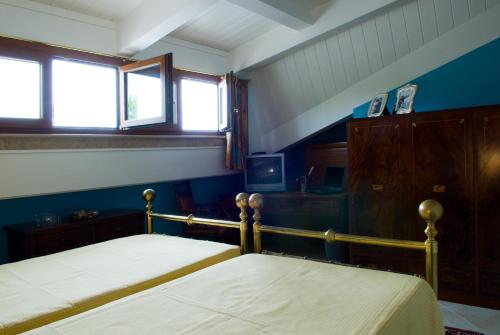 two beds in a room with two windows at Lo Squero Rooms and Apartments in Fano