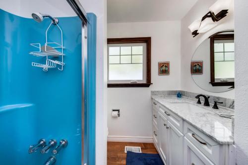 a bathroom with a blue shower door and a sink at Shore Pine Hideaway in Lincoln City