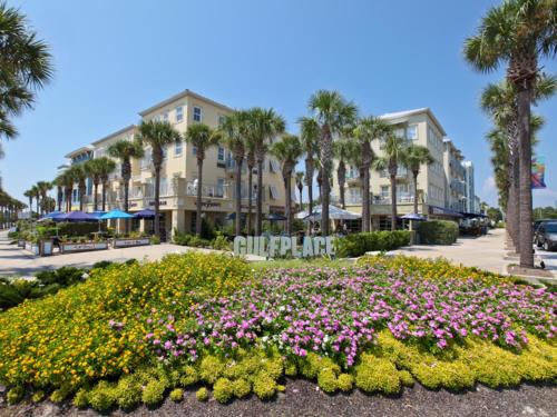 
a row of palm trees in front of a large building at Inn at Gulf Place in Santa Rosa Beach
