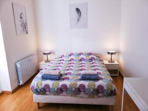 une chambre avec un grand lit avec deux tables de nuit dans l'établissement Le duc de Vichy, à Vichy