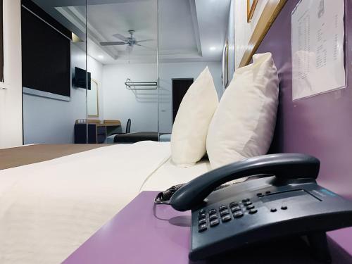 a telephone sitting on a bed in a room at Hotel Menara in Mexico City