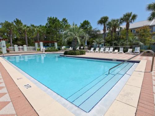 a swimming pool at a resort with chairs and trees at Inn at Gulf Place in Santa Rosa Beach