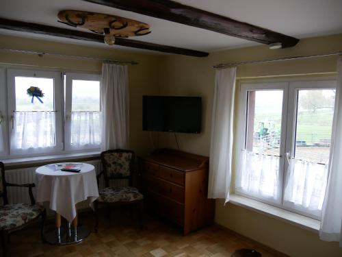 un soggiorno con tavolo e 2 finestre di Western-Inn a Klipphausen