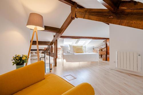 een woonkamer met een gele bank en een bed bij BestVillas Casa do Rio in Vila Nova de Gaia