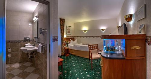 a bathroom with a room with a bed and a fish tank at Landhotel Schwarzer Adler in Sülzetal