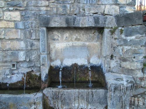 a water fountain in a stone wall at La Casita de Ordesa in Frajén