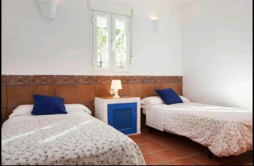 a bedroom with two beds and a television in it at Las Casillas Del Cabo in Las Hortichuelas
