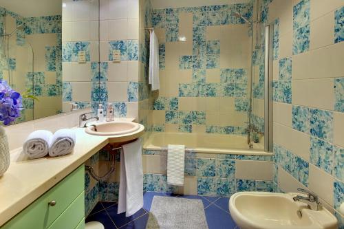 アルブフェイラにあるMarina Ocean Residenceの青と白のバスルーム(シンク、バスタブ付)