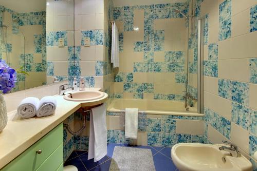 a blue and white bathroom with a sink and a tub at Marina Ocean Residence in Albufeira