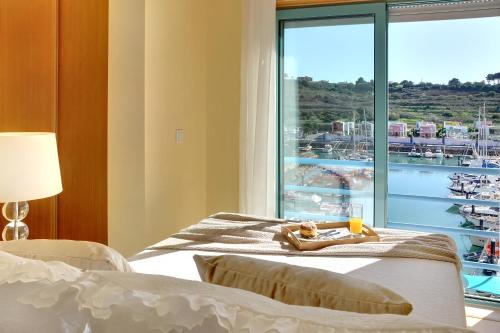 アルブフェイラにあるMarina Ocean Residenceのベッドルーム1室(ベッド2台付)、景色を望む窓が備わります。