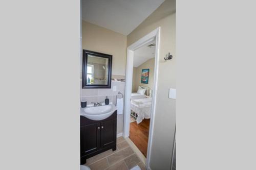 ein Bad mit einem Waschbecken und einem Spiegel in der Unterkunft NEW 4BR in AC Quiet Island Central Location in Atlantic City