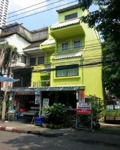 a yellow building on the side of a street at Swan inn 2 Nana in Bangkok