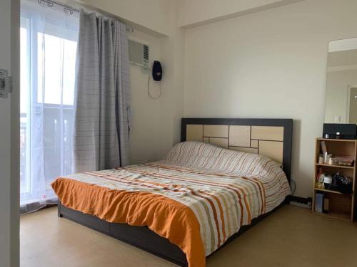- une chambre avec un lit et une grande fenêtre dans l'établissement Wind Residence T4- H Near Taal view & sky ranch, à Nasugbu