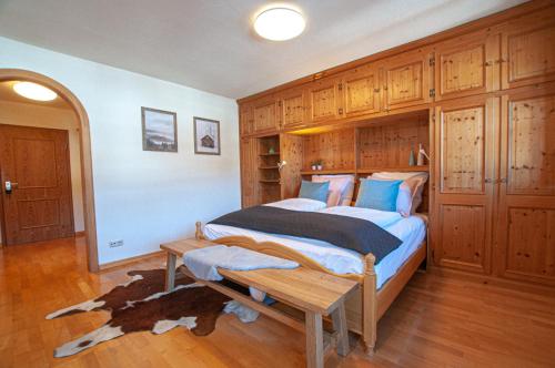 Schlafzimmer mit einem Bett mit einer Bank in der Unterkunft Tegernsee Freihaus Studio in Bad Wiessee