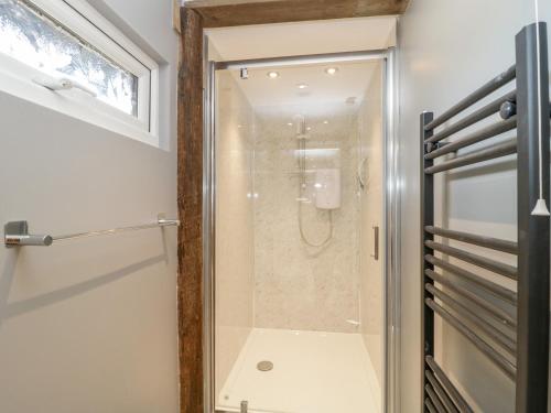 a shower with a glass door in a bathroom at Deer Lodge in Wimborne Minster