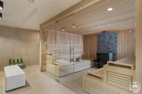 a room with a sauna with a glass wall at Nadmorskie Tarasy - Apartments M&M in Kołobrzeg