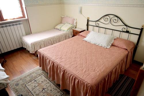 a bedroom with two beds with pink sheets and a window at B&B La Vela in Rieti