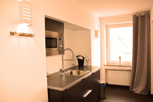 a kitchen with a sink, stove, and refrigerator at Hotel Walsroder Hof in Walsrode
