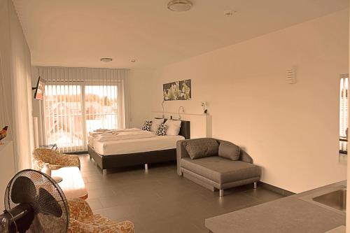 a bedroom with a bed and a chair at Hotel Walsroder Hof in Walsrode