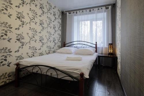 a bedroom with a bed with white sheets and a window at ОК! Усова, 25/1 №1 in Tomsk