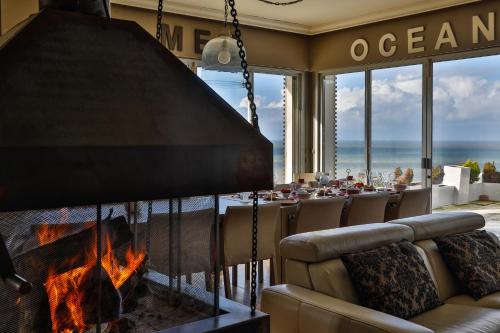 a dining room with a fireplace and a table with a view of the ocean at Domaine du Grand Bec in Villerville