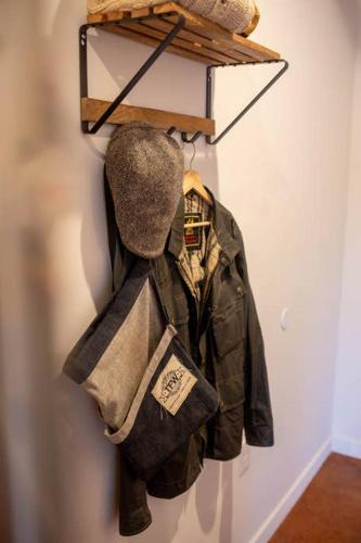 a jacket and hat hanging on a wall at Poor Richard Studio at Kestrel Hotel in Philadelphia