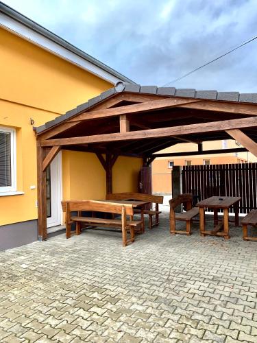 a pavilion with picnic tables and benches on a patio at Pohoda Ubytovanie Stupava in Stupava