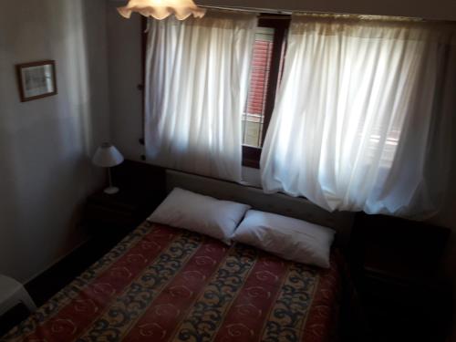 1 dormitorio con 1 cama y una ventana con cortinas blancas en Departamento para 6 personas San Bernardo en San Bernardo