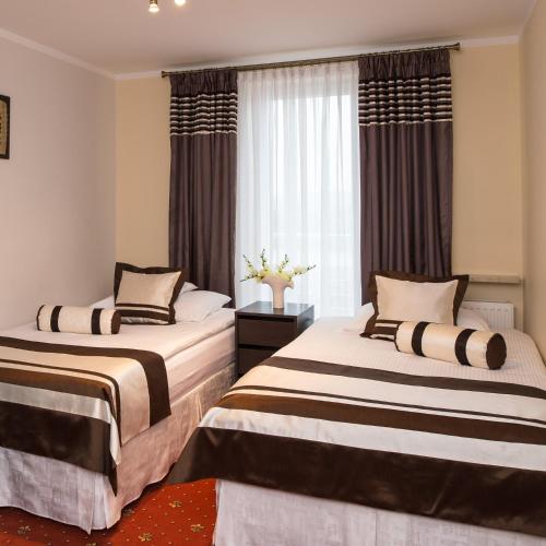 2 camas en una habitación con ventana en Motel LESTA, en Lachówka Duża