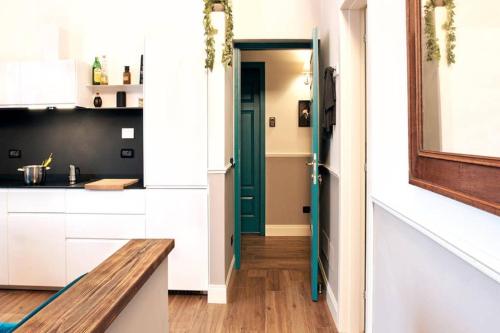 una cocina con armarios blancos y una puerta verde en Dandy house on the Arno river, en Florencia