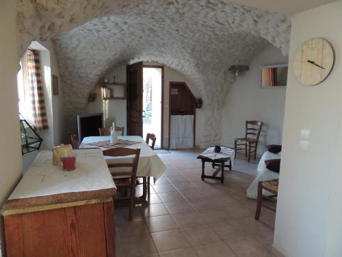 une salle à manger avec une table et une horloge au mur dans l'établissement Les grands bois, à Gap