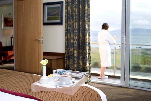a woman looking out the window of a hotel room at Connemara Coast Hotel in Furbo