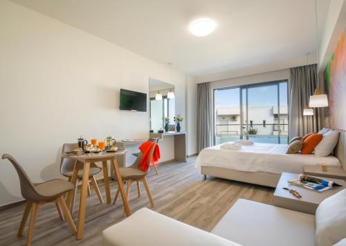 a hotel room with a bed and a table and chairs at Incognito Creta Luxury Suites and More in Kolymvari