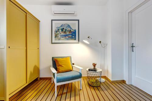 a living room with a chair and a yellow pillow at Apartments Viola in Zagreb